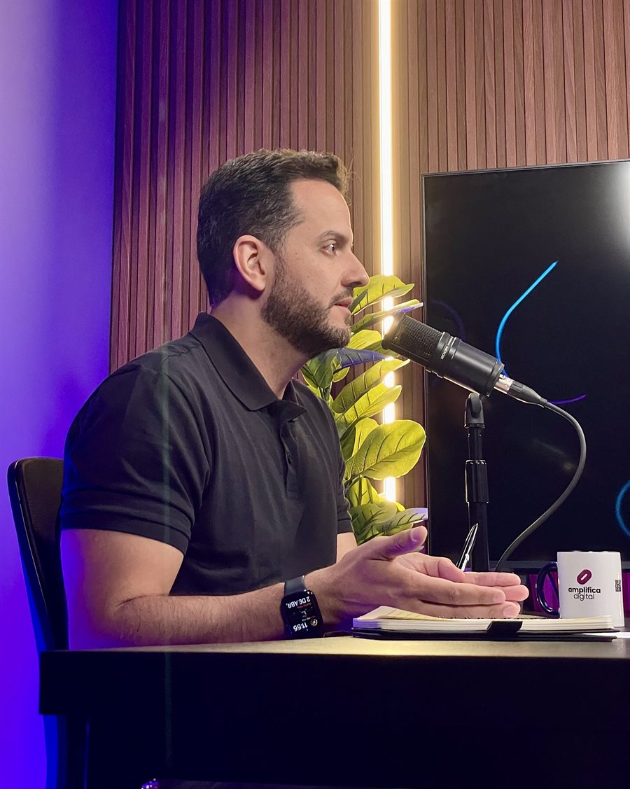 Eric Klein em estúdio durante gravação, falando ao microfone em ambiente de conteúdo.